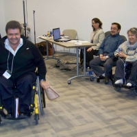 A participant has received his award and is approaching the camera  as the presenters clap.