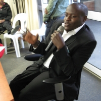 <p>
	Oswald Tuyizere holds a microphone during the session while seated.</p>
