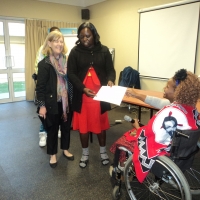 Bongiwe Malope is issuing certificate to Roseweter Mudarikwa, while Marcia Rioux looks on nearby.