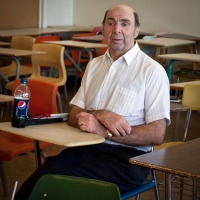 Paul Morgan sitting at a small desk.