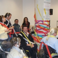 Celebration photo at the end of the training, participants are covered in streamers and there is a large pole in the middle of the photo which is covered as well.