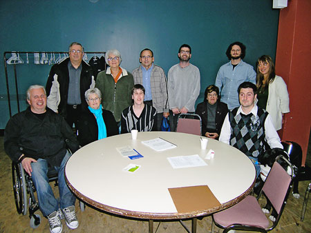 Workshop participants pose for a photo around a circular table