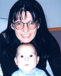 Cyndy Baskin smiles while holding a baby in her lap.