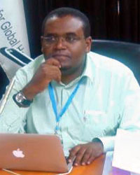 Dagnachew Wakene is seated at a desk with a laptop in front of him