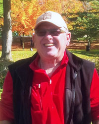 A photo of David McNab smiling while outside on a sunny Autumn day.