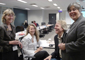 Marcia Rioux, Roxanne Mykitiuk, Ivana Petricone, and Michael Prince smiling and laughing in the meeting room.