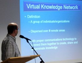 Christo El Morr speaks into a microphone during the Virtual Knowledge Network presentation