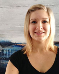 Patricia Lamotte smiles while standing in front of a large painting.