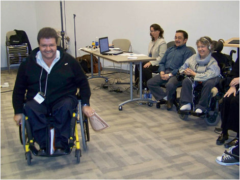 Raynald Pelletier dans son fauteuil roulant devant des collègues
