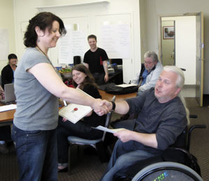 Lorraine Irlam shakes hands with Normand Boucher while recieving her training certificate.
